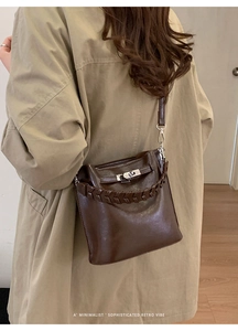 Detailansicht braune Retro-Eimertasche mit geflochtenem Griff und Metall-Drehverschluss