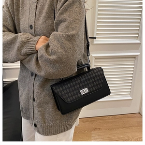 Detail of crossbody bag featuring black quilted rhombus pattern and silver rotary lock