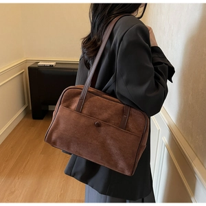 Detail of vintage brown suede shoulder bag with front pocket and shoulder strap