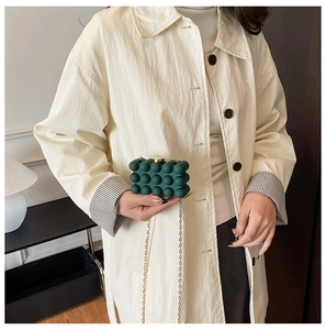 Detail of dark green bubble texture acrylic clutch with gold round clasp and chain