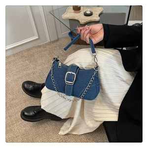 Vue latérale détaillée du sac baguette en denim bleu avec chaîne argentée et bandoulière