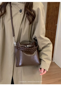Nahaufnahme der braunen Vintage-Ledertasche mit gewebtem Griff und silbernem Drehverschluss