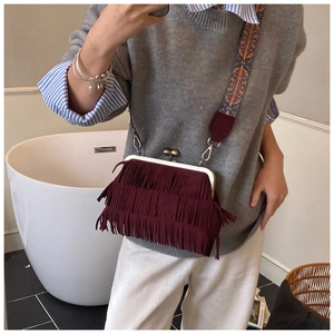 Détail du sac à franges bordeaux avec fermoir rétro et bandoulière à motif ethnique