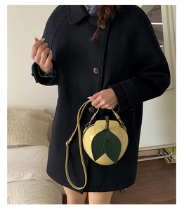 Détail d'un mini sac créatif jaune en forme de poire avec feuille verte et aspect brillant
