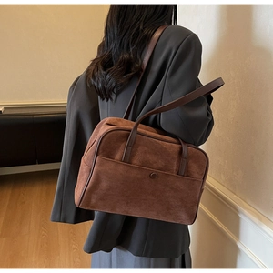 Brown frosted suede shoulder bag shown on model highlighting the elegant texture and size