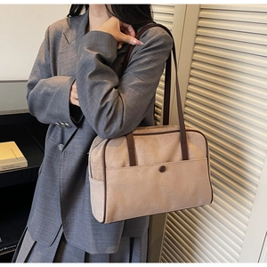 Detail of vintage beige suede tote bag with brown trim and front pocket with snap closure