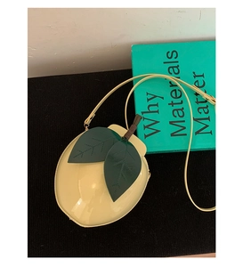 Détail du sac bandoulière en forme de citron avec fini brillant et détails de feuilles