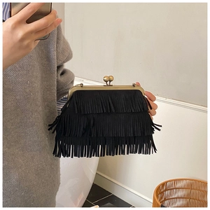 Détail de sac à main vintage à franges noires avec fermoir en bronze et texture daim