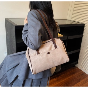 Vintage beige nubuck shoulder bag detail shown with formal blazer and pleated skirt