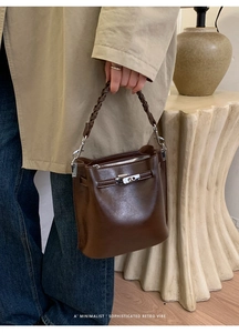 Detail der dunkelbraunen Retro-Beuteltasche mit Flechtgriff und Metall-Drehverschluss