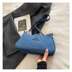 Détail du sac hobo en denim bleu avec surpiqûres blanches et boucle métallique élégante