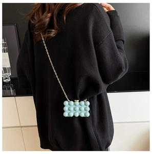 Light blue bubble texture acrylic mini bag with gold chain strap shown on model back