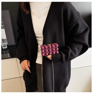 Detail of purple bubble texture acrylic box bag with gold chain and spherical clasp