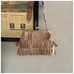 Détail du sac bandoulière vintage en daim marron avec franges et sangle tissée