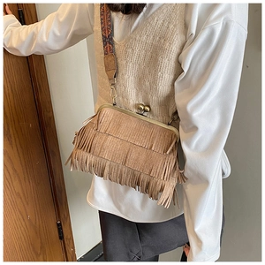 Détail d'un sac à franges marron vintage avec fermoir bronze et bandoulière ethnique