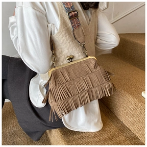 Détail du sac à franges en daim marron vintage avec large bandoulière à motifs ethniques