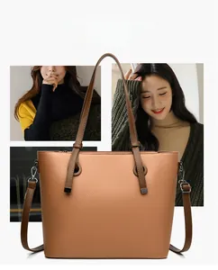 Detail view of large brown pebble leather tote bag with silver D-rings and long shoulder strap