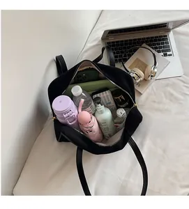 Detail view of large capacity black tote bag showing spacious interior with daily essentials