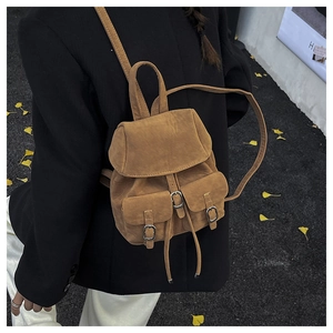 Detail of vintage brown textured backpack with silver buckles in an autumn setting