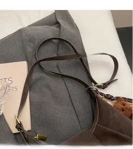 Detail of dark brown matte crossbody bag with adjustable strap and cute bear charm