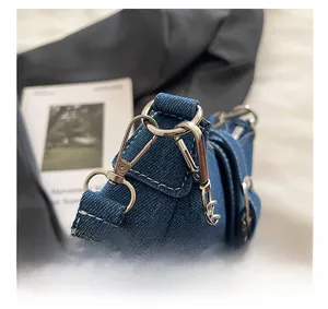 Détail de la quincaillerie métallique argentée et fermoir sur sac en denim bleu