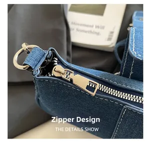 Détail macro de la fermeture éclair en métal argenté et surpiqûres sur sac en jean bleu