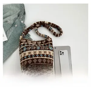 Detail of plush jacquard shoulder bag with brown reindeer patterns and soft texture