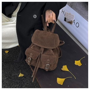 Detail of dark brown suede mini backpack with drawstring closure and silver buckles