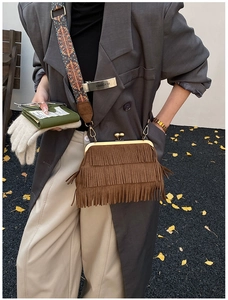 Détail du sac bandoulière en daim marron avec franges et bandoulière ethnique tissée