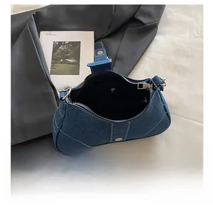 Détails de l'intérieur d'un sac baguette en jean bleu avec fermeture éclair argentée