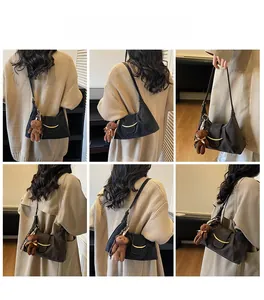 Detailed views of a black half-moon shoulder bag featuring a gold buckle and teddy bear charm