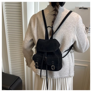 Rear view of a model wearing a black matte suede mini backpack with vintage buckles