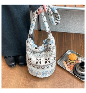 Detail of plush winter bucket bag with Fair Isle pattern and lamb wool texture