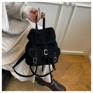 Close-up of black suede mini backpack featuring vintage metal buckles and dual front pockets