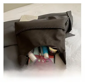 Detailed interior view showing large capacity for tablet and cosmetics in dark brown woven bag
