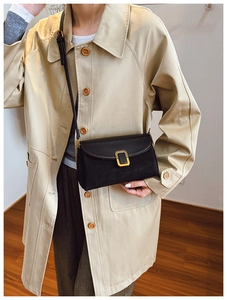 Modern black leather crossbody bag with gold buckle shown on professional model