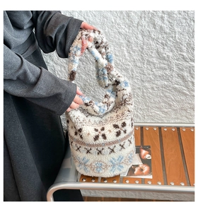 Close-up of plush lamb wool bucket bag with blue and brown snowflake jacquard texture