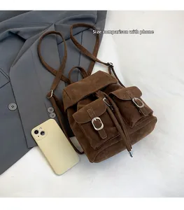 Mini brown suede backpack with double buckle pockets and drawstring closure, mobile phone for size scale