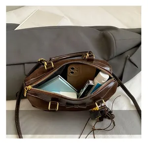 Vue de dessus d'un sac à main en daim marron avec nœud montrant l'espace intérieur spacieux