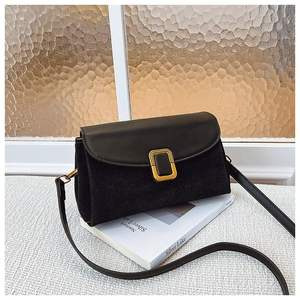 Detail of a black leather flap handbag with a square gold buckle and matte texture