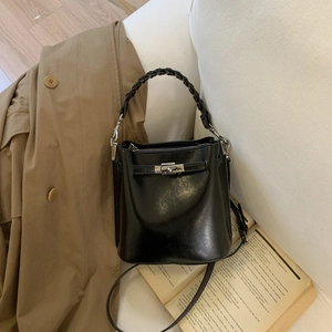 Schicke schwarze Beuteltasche aus Leder mit geflochtenem Griff und silbernem Drehverschluss