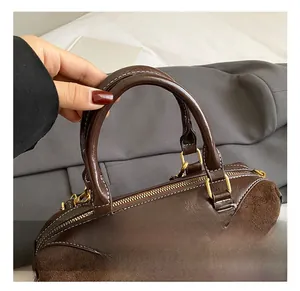 Détail de la poignée du sac rétro avec cuir mixte et fermeture éclair dorée
