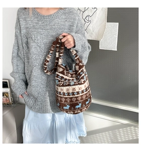 Detail of plush winter tote bag featuring blue reindeer patterns and soft fleece texture