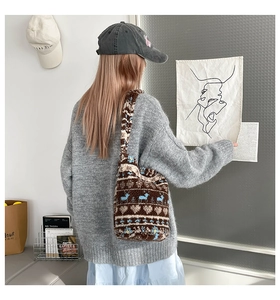 Detail of plush brown tote bag with deer pattern shown on model in modern setting
