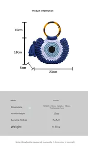 Détail d'un sac en tricot avec poignées en résine, motif œil et breloque à franges