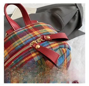 Detail of golden metal zippers and colorful plaid fabric on a stylish backpack
