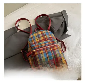 Detail of colorful plaid mini backpack with red leather straps and gold metal hardware