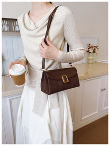 Detail of vintage brown shoulder bag showing smooth leather and suede texture contrast