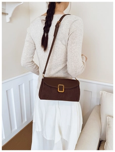 Brown vintage shoulder bag with gold clasp shown on model for a sleek minimalist look