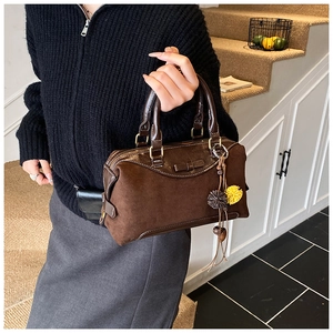 Detail of dark brown Boston handbag in mixed suede and leather with plush charms